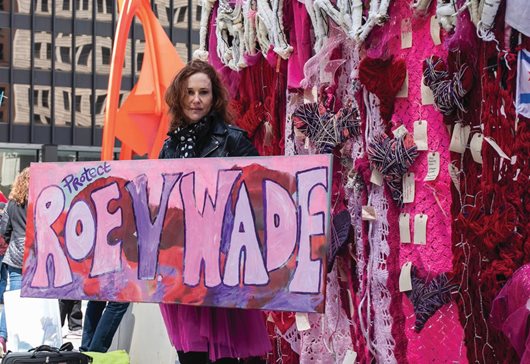 Artist Jacqueline Von Edelberg poses with an installation she created during an abortion-rights rally at Federal Plaza in the Loop on Saturday. The as-yet anonymous leak of a U.S. Supreme Court draft ruling overturning Roe v. Wade set off demonstrations nationwide.