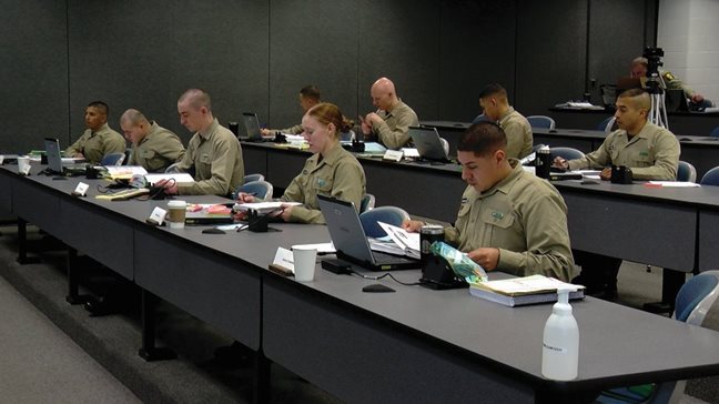 Illinois State Police Cadet Class 145 participates in classroom training. Only one of the nine cadets in the class is a woman.